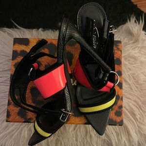 Woman’s strappy pink, black and neon yellow heels for elegant occasion